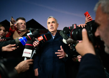 Calin Georgescu (C), far-right pro-Russia candidate for president in Romania, speaks with journalists on November 26, 2024 in Izvorani, Romania. (Photo by Daniel MIHAILESCU / AFP)